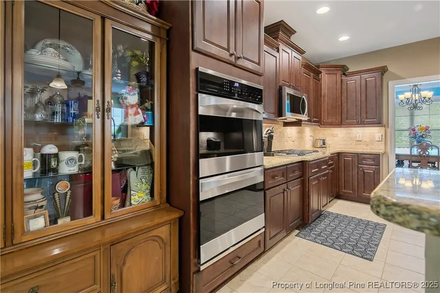 a kitchen with granite countertop stainless steel appliances and wooden cabinets