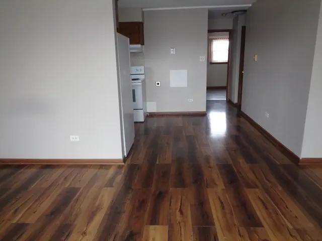 a view of a room with wooden floor and a fireplace