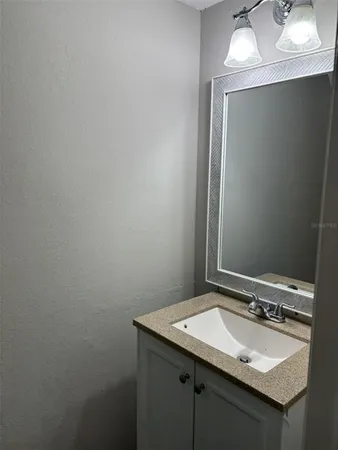 a bathroom with a granite countertop sink and a mirror