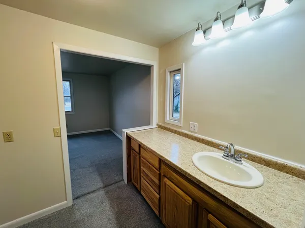 a bathroom with a granite countertop sink and a mirror