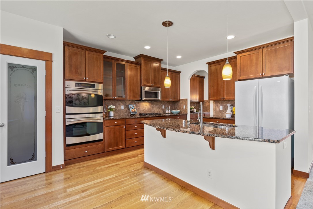 3603 222nd Place Southeast Bothell, WA 98021 - Photo 12 of 40 a kitchen with stainless steel appliances a refrigerator and a stove top oven