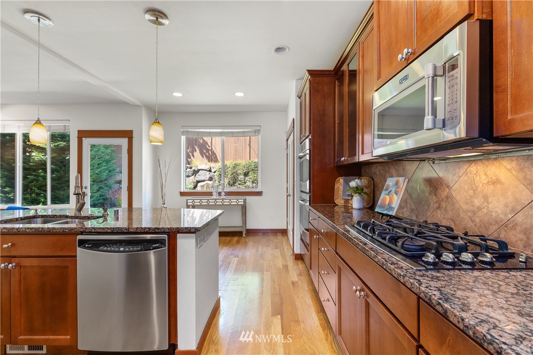 3603 222nd Place Southeast Bothell, WA 98021 - Photo 8 of 40 a kitchen with stainless steel appliances granite countertop a stove a sink and a microwave
