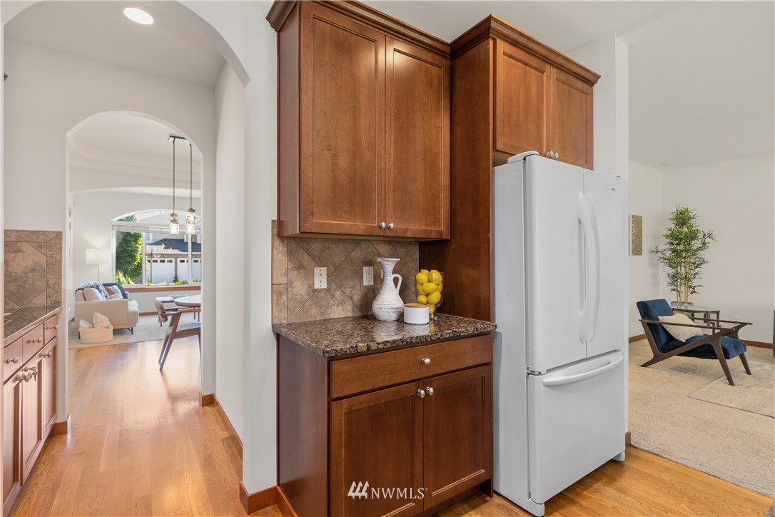 3603 222nd Place Southeast Bothell, WA 98021 - Photo 10 of 40 a kitchen with stainless steel appliances granite countertop a refrigerator a sink dishwasher and white cabinets with wooden floor