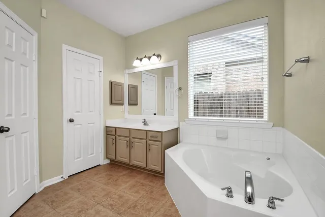a bathroom with a bathtub sink double and mirror