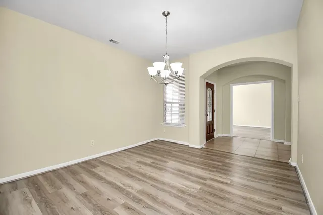 a view of a room with wooden floor and chandelier