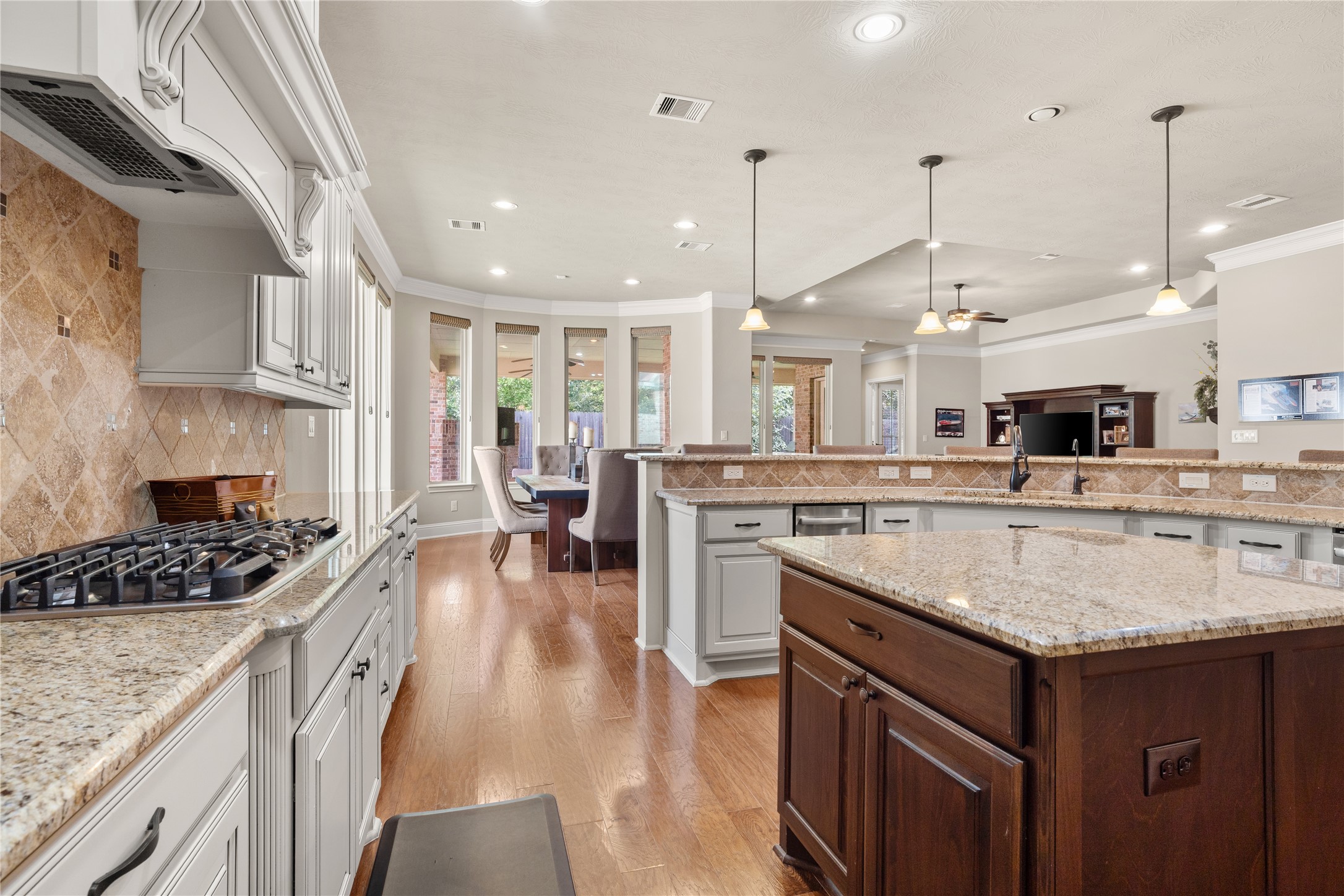 19813 Cullen Ridge Drive Porter, TX 77365 - Photo 12 of 44 This spacious kitchen, featuring a sleek gas stove perfect for unleashing your inner chef, is an ideal blend of elegance and functionality, set against warm hardwood floors and expansive countertops.