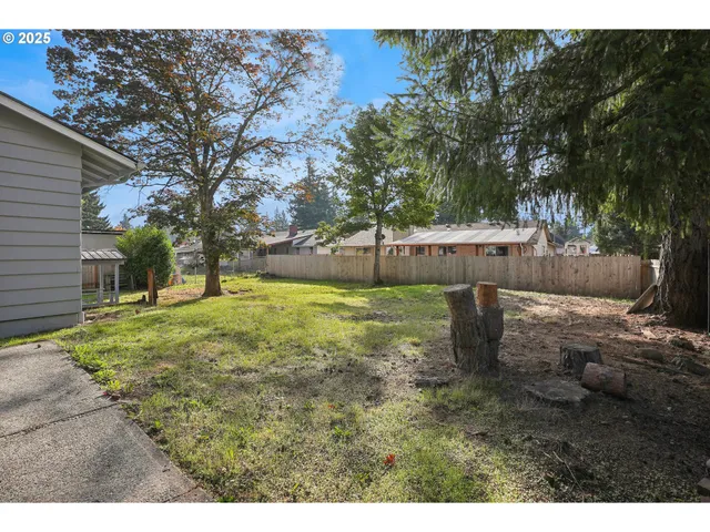a backyard of a house with table and chairs