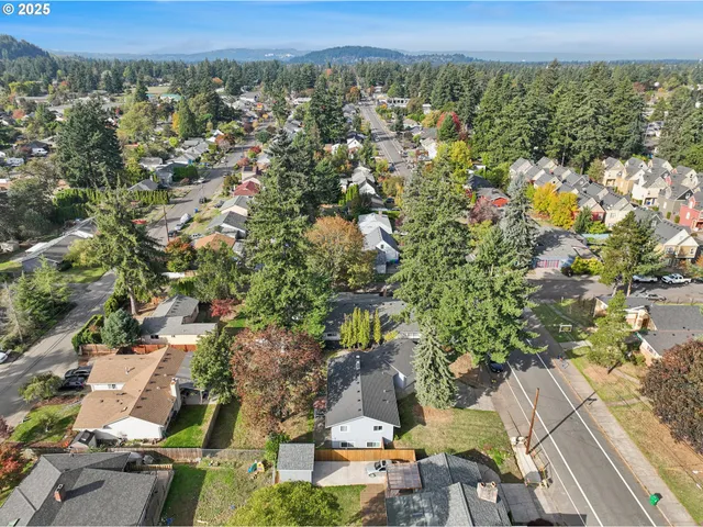 an aerial view of residential house with outdoor space and trees all around