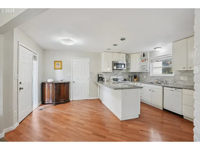 a kitchen with granite countertop a stove top oven sink and cabinets