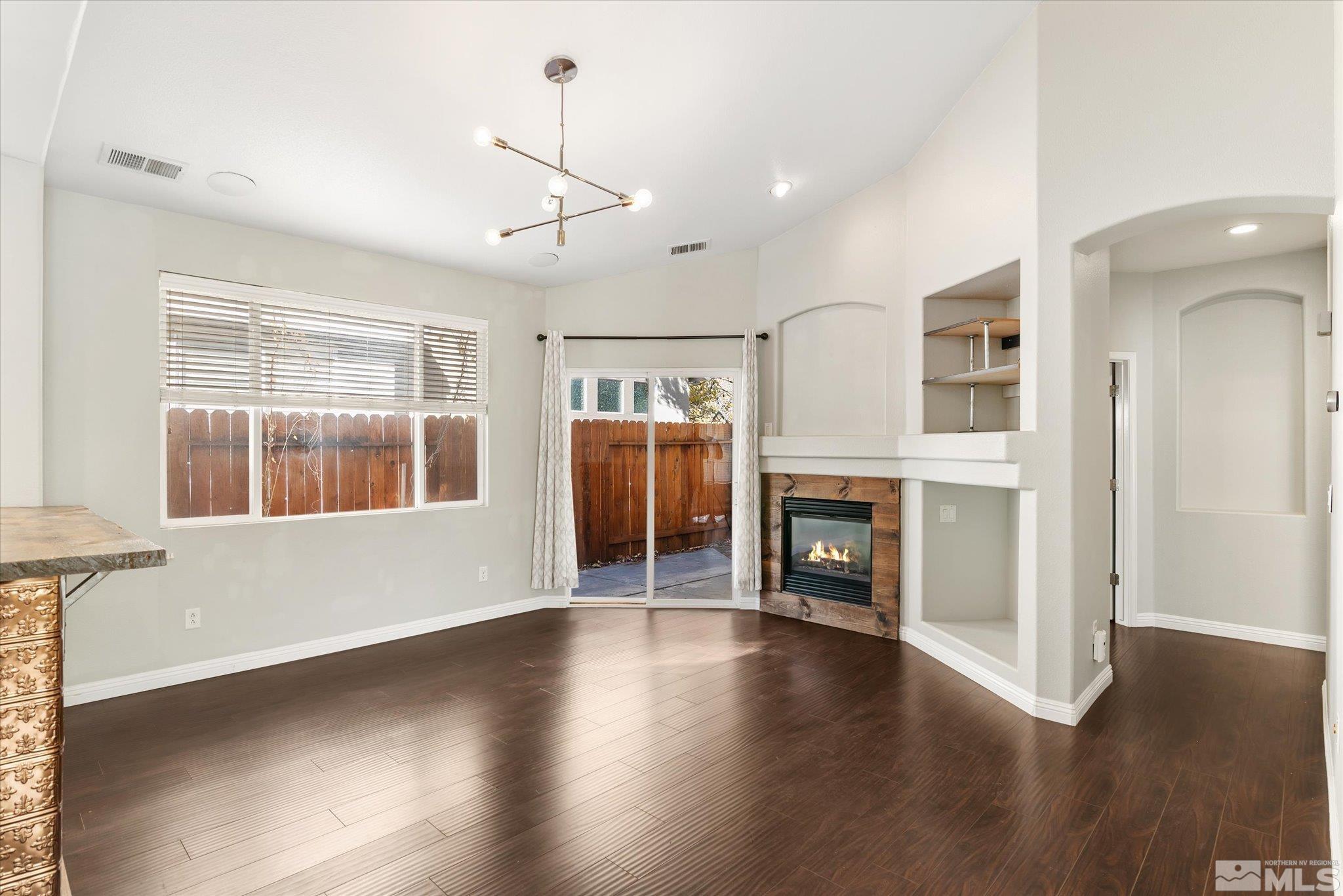 1197 Tule Drive Reno, NV 89521 - Photo 14 of 30 an empty room with wooden floor fireplace and windows
