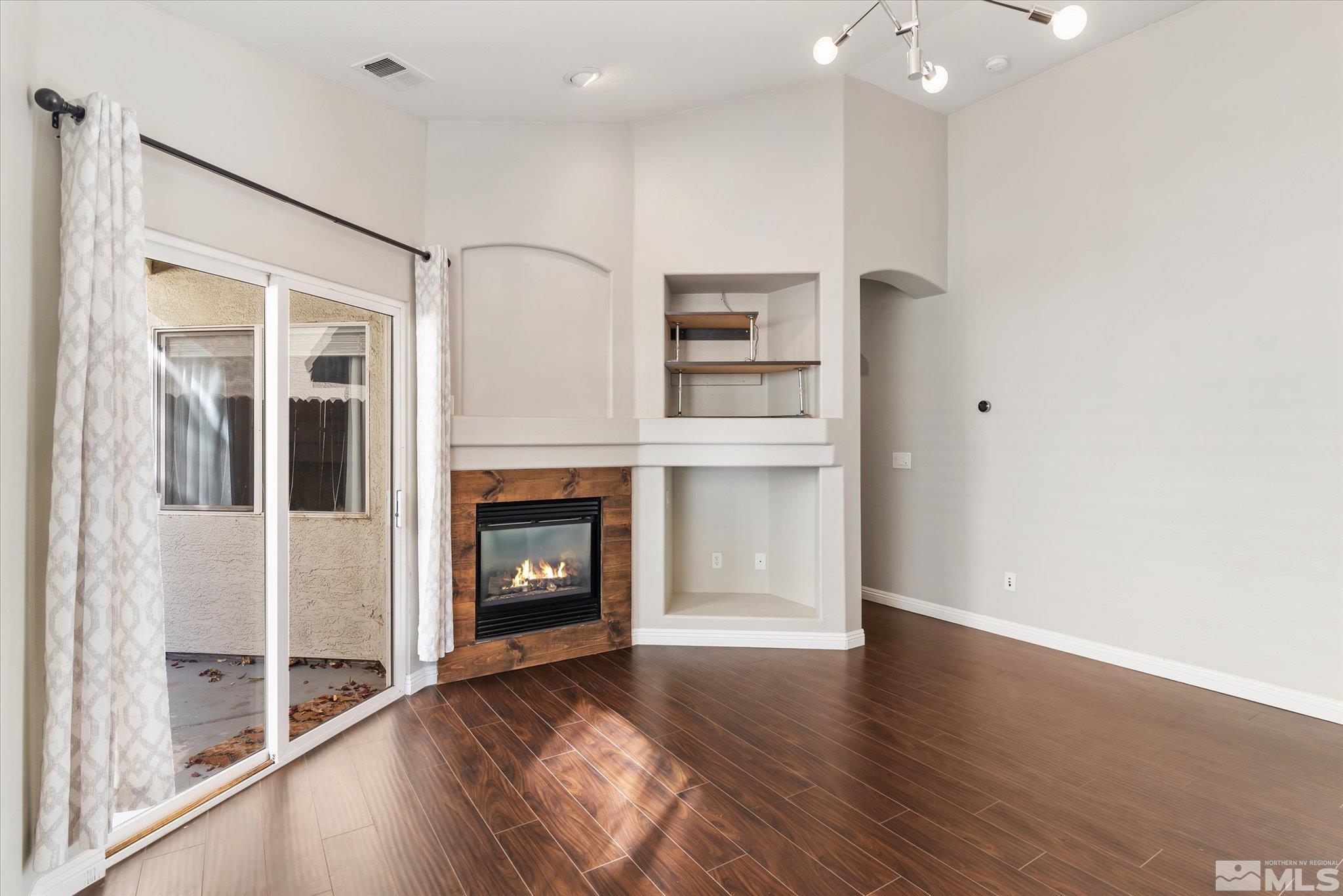 1197 Tule Drive Reno, NV 89521 - Photo 15 of 30 a view of a livingroom with wooden floor and a fireplace