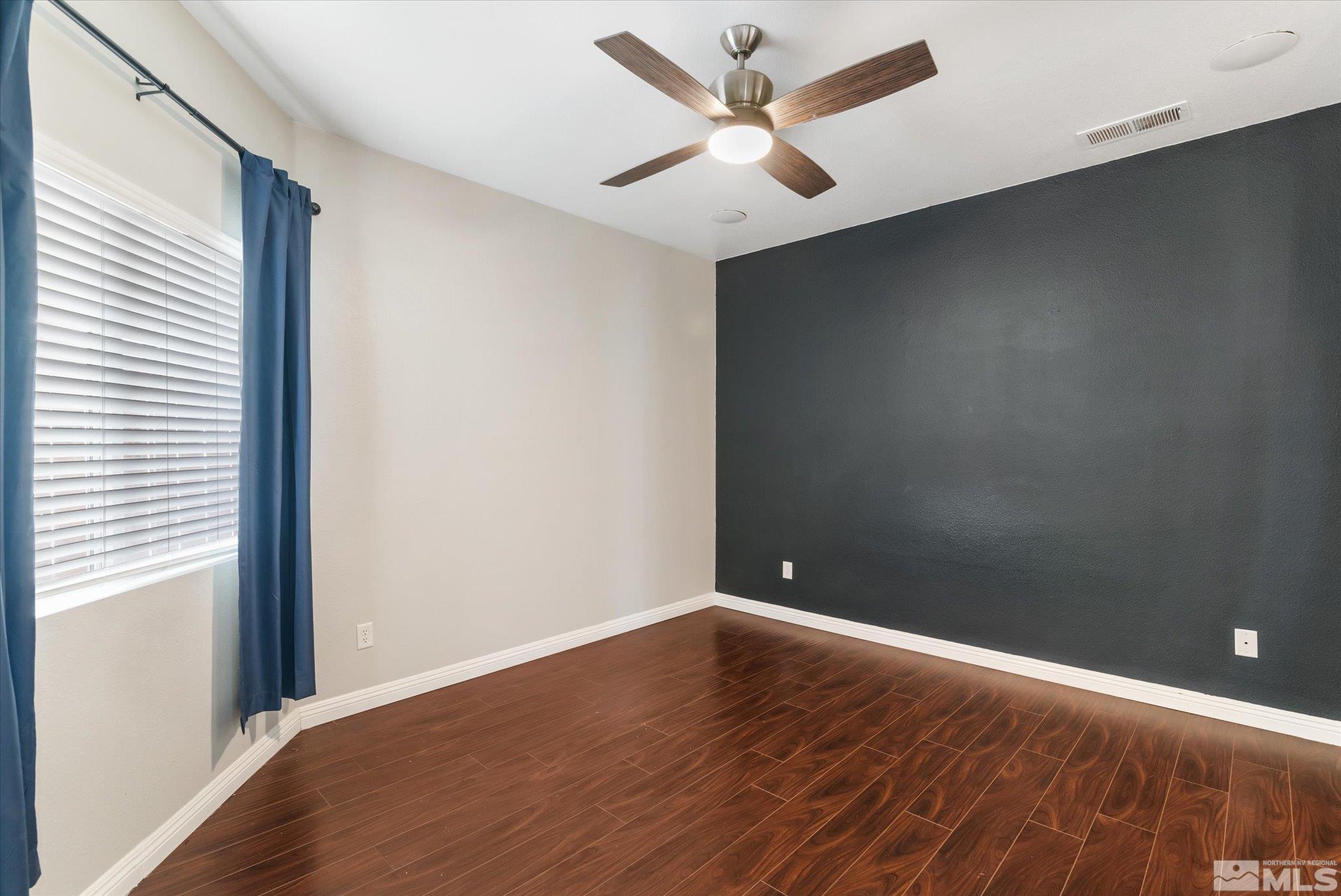 1197 Tule Drive Reno, NV 89521 - Photo 17 of 30 an empty room with wooden floor and windows