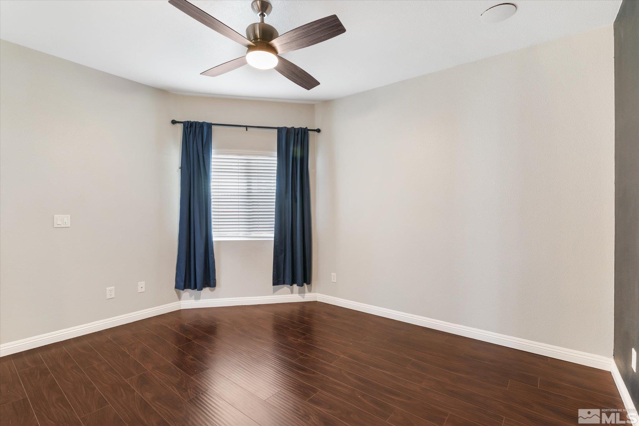 1197 Tule Drive Reno, NV 89521 - Photo 18 of 30 an empty room with wooden floor fan and windows