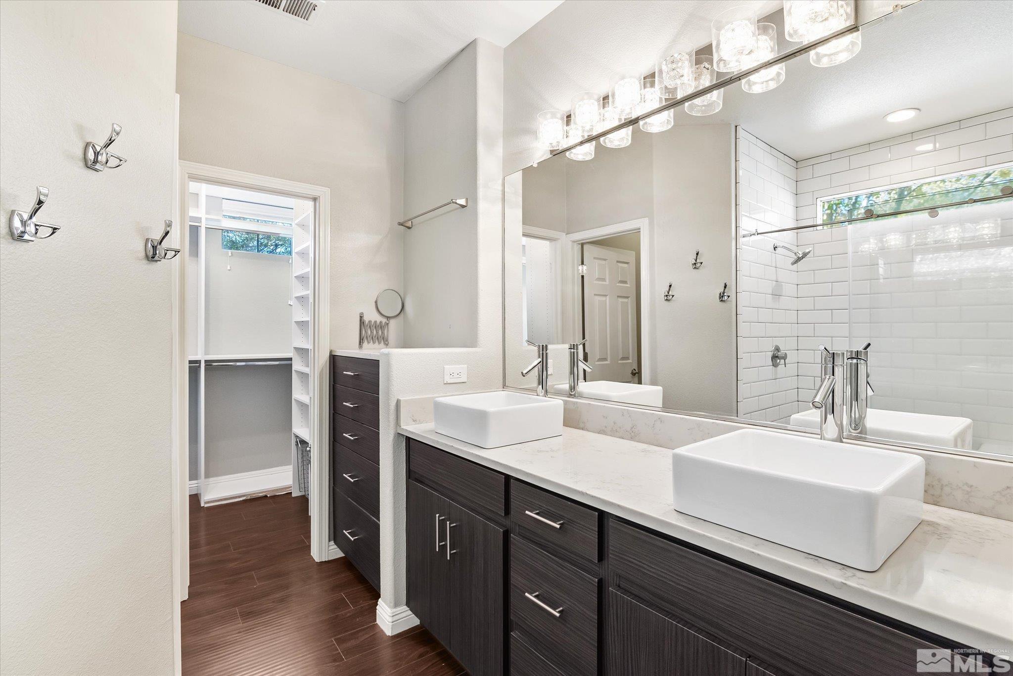 1197 Tule Drive Reno, NV 89521 - Photo 20 of 30 a bathroom with a double vanity sink a mirror and shower