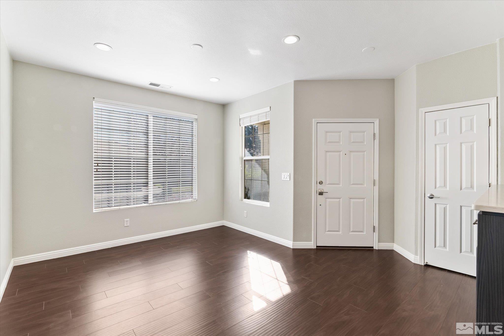1197 Tule Drive Reno, NV 89521 - Photo 5 of 30 an empty room with wooden floor and windows
