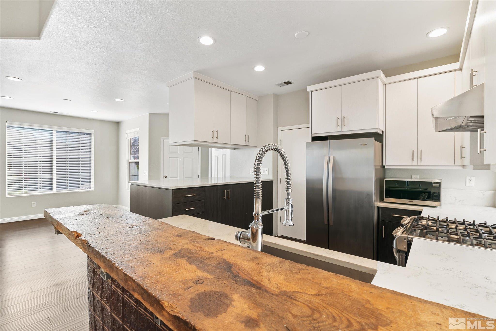 1197 Tule Drive Reno, NV 89521 - Photo 9 of 30 a kitchen with stainless steel appliances kitchen island granite countertop a refrigerator and a stove top oven