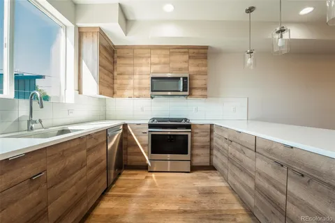 a kitchen with granite countertop a sink cabinets and stainless steel appliances