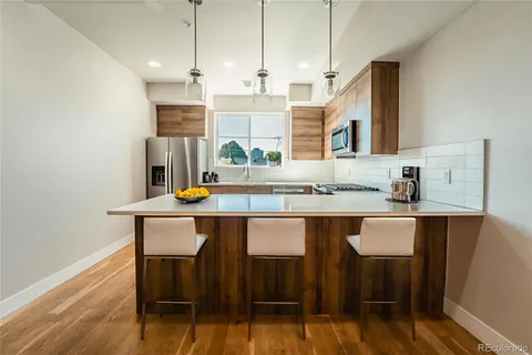 a kitchen with a table chairs sink and cabinets