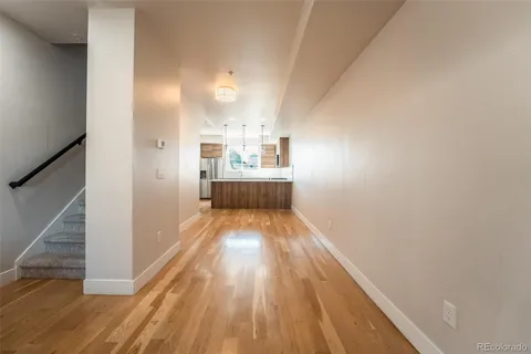 a view of a hallway with wooden floor and staircase