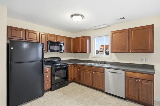 a kitchen with stainless steel appliances granite countertop a refrigerator sink and cabinets
