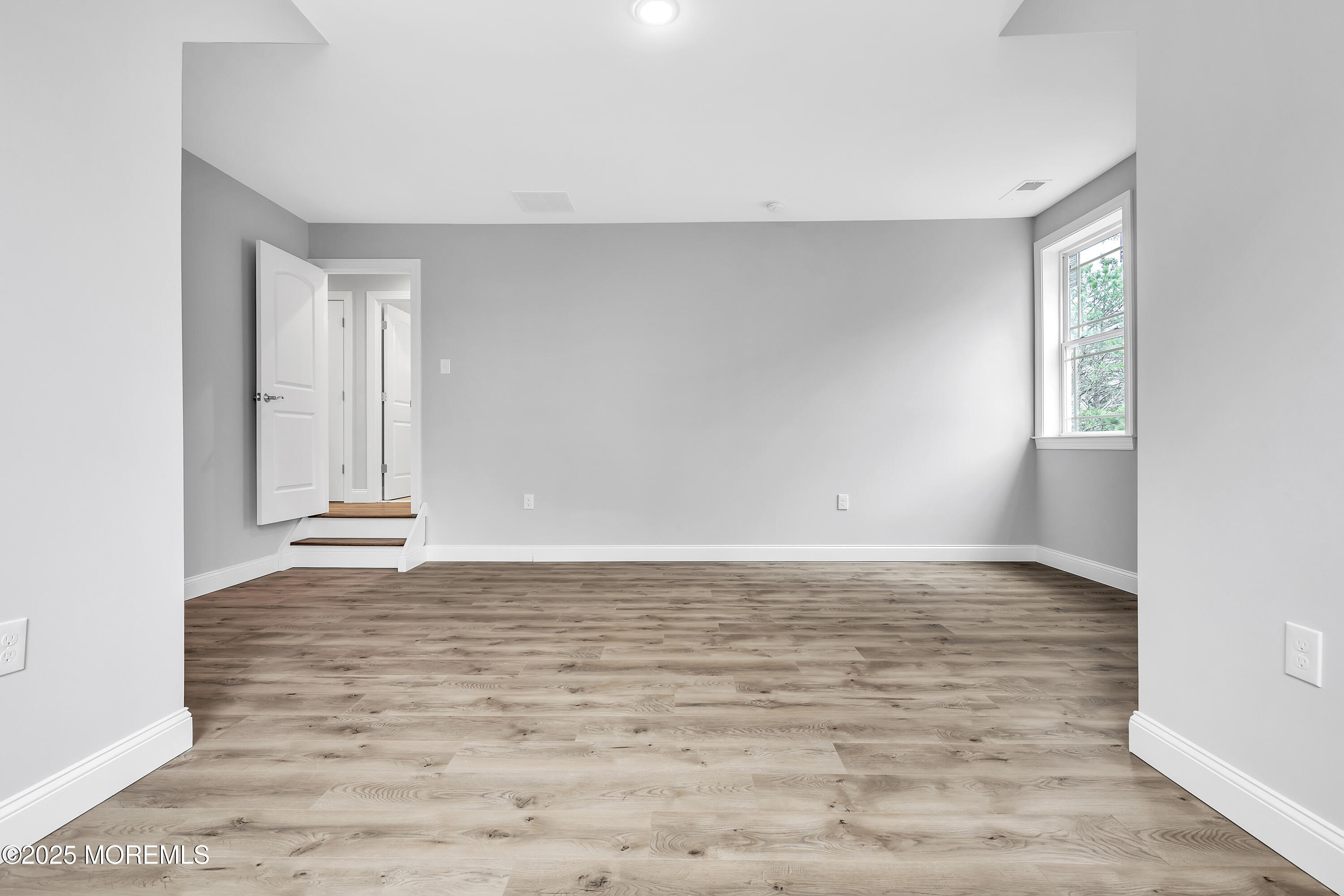 217 Nantucket Road Forked River, NJ 08731 - Photo 18 of 38 a view of an empty room with window and wooden floor