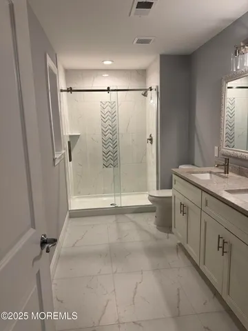 a bathroom with a shower sink and mirror