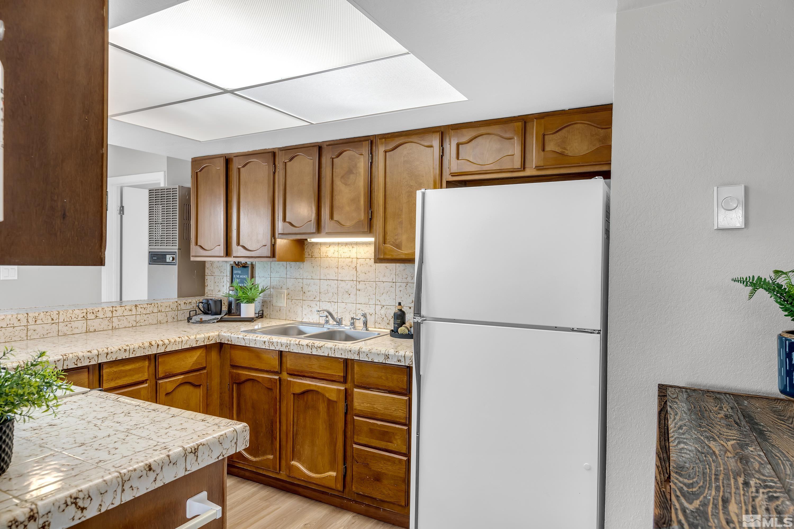1415 Ebbetts Drive Reno, NV 89503 - Photo 26 of 36 a kitchen with a sink a refrigerator and cabinets