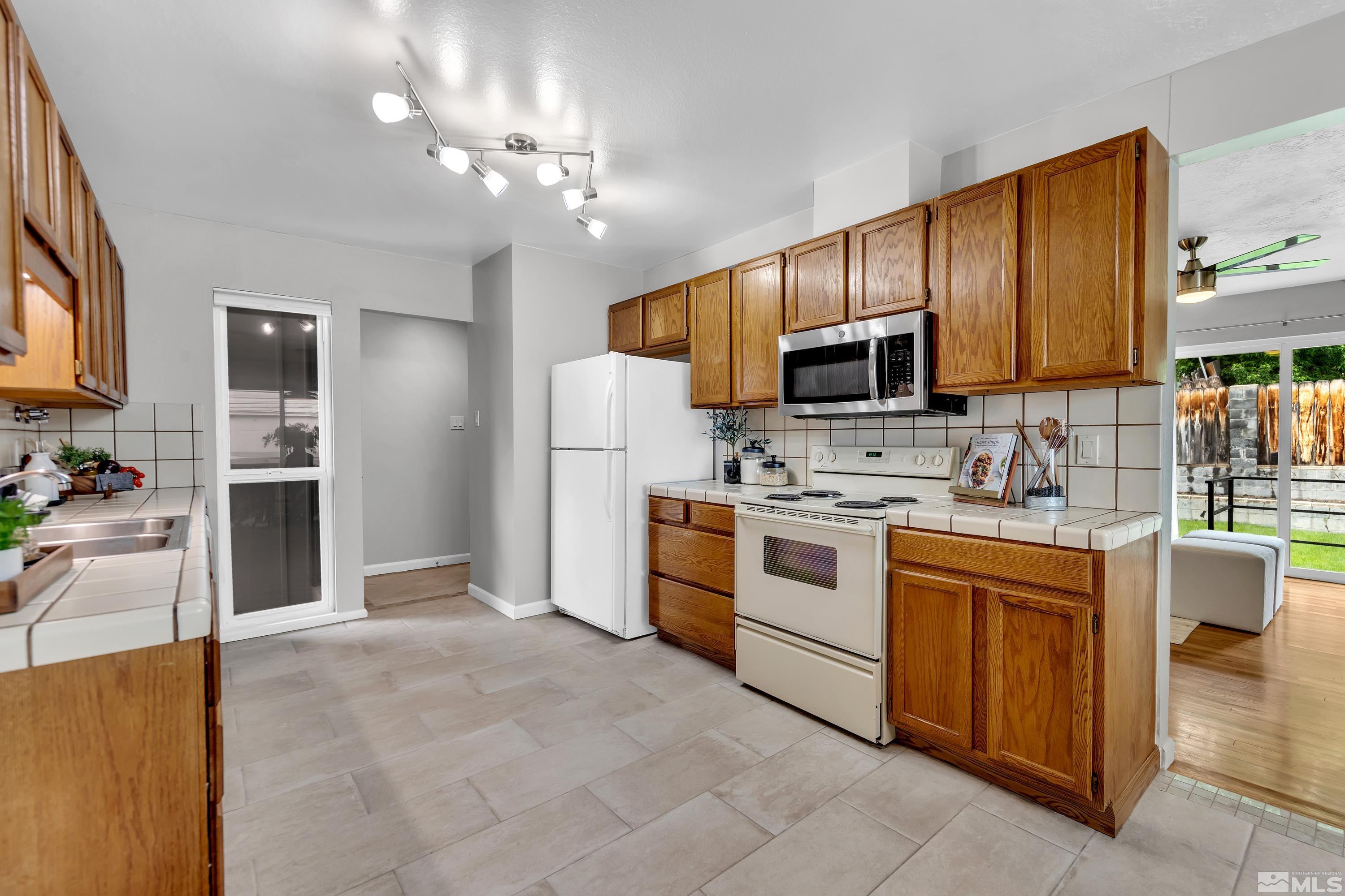 1415 Ebbetts Drive Reno, NV 89503 - Photo 9 of 36 a kitchen with stainless steel appliances a stove sink microwave and cabinets