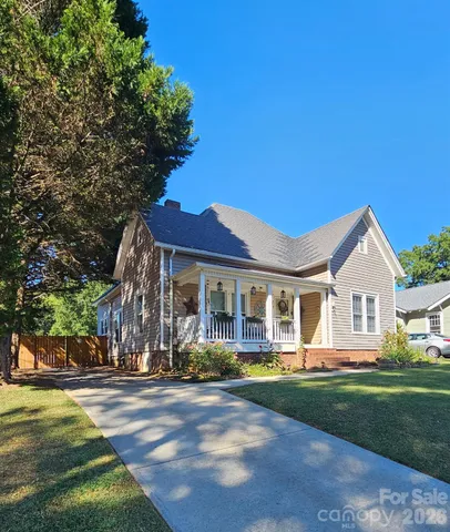 a front view of a house with a garden and lake view