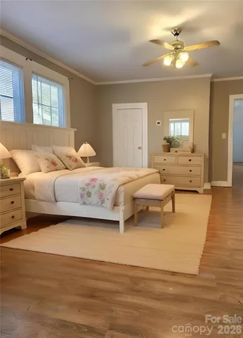 a bedroom with a bed couches and wooden floor