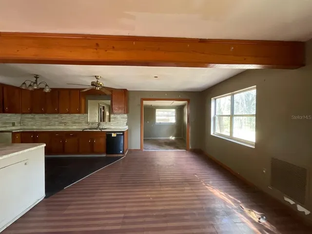 a view of a kitchen with a sink and dishwasher with wooden floor
