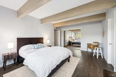 a bedroom with a bed and a table in it with wooden floor