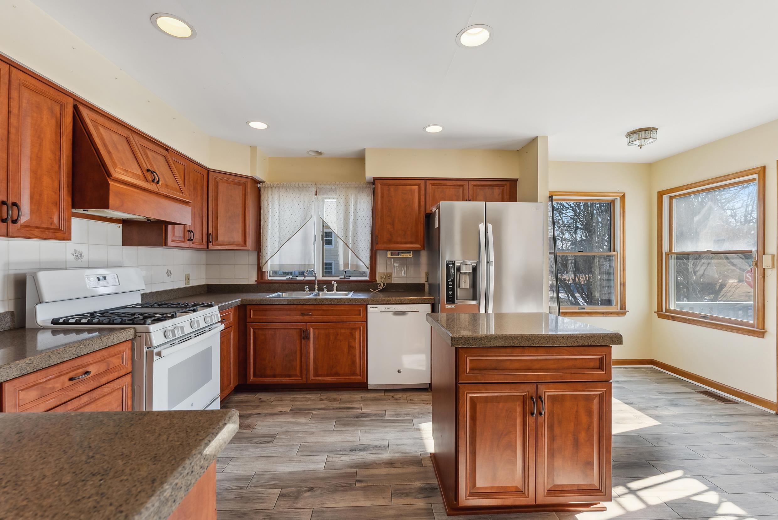 401 4th West Cape May, NJ 08204 - Photo 7 of 43 a kitchen with stainless steel appliances granite countertop a stove a sink dishwasher a refrigerator and white cabinets with wooden floor