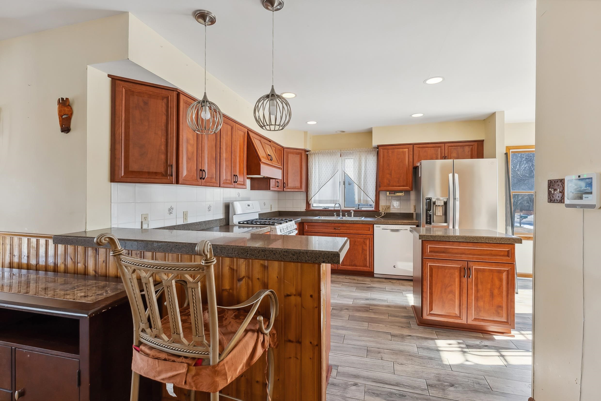401 4th West Cape May, NJ 08204 - Photo 8 of 43 a kitchen with stainless steel appliances granite countertop a kitchen island a stove a refrigerator a sink a dining table and chairs with wooden floor