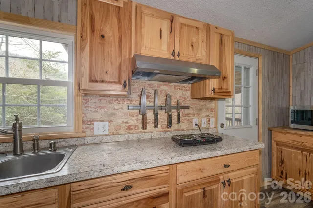 a kitchen with granite countertop a sink cabinets and window