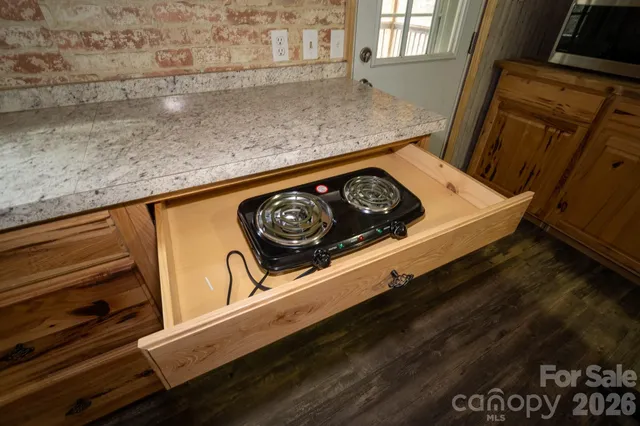 a kitchen with stainless steel appliances a refrigerator a stove a dining table and chairs with wooden floor