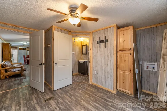 a view of a hallway view with wooden floor and a bathroom
