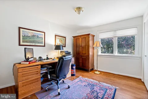 a view of a workspace with furniture and a window