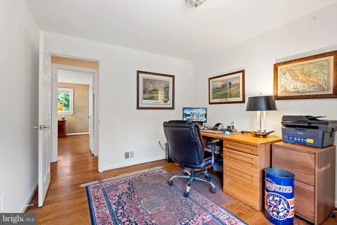 a view of a workspace with furniture and wooden floor