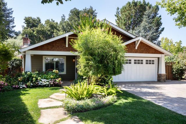 a front view of house with a garden