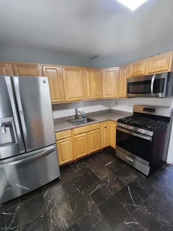 a kitchen with granite countertop a sink stainless steel appliances and cabinets