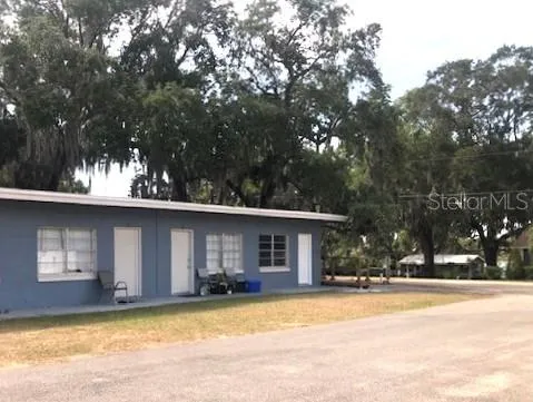 a view of a house with a yard and large tree