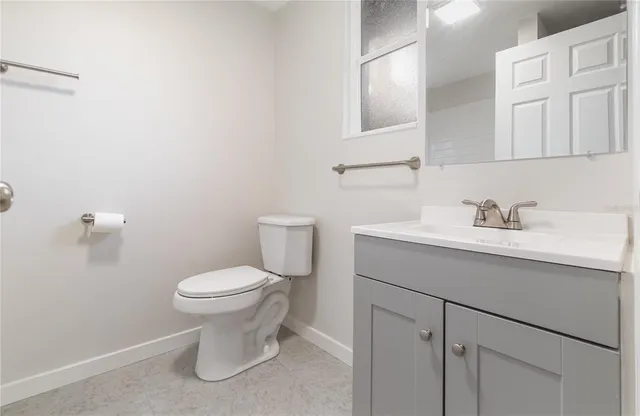 a bathroom with a sink toilet and a mirror