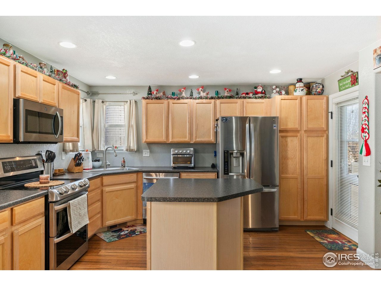 11420 Coal Ridge Street Firestone, CO 80504 - Photo 9 of 31 a kitchen with stainless steel appliances granite countertop a refrigerator a stove a sink and a microwave