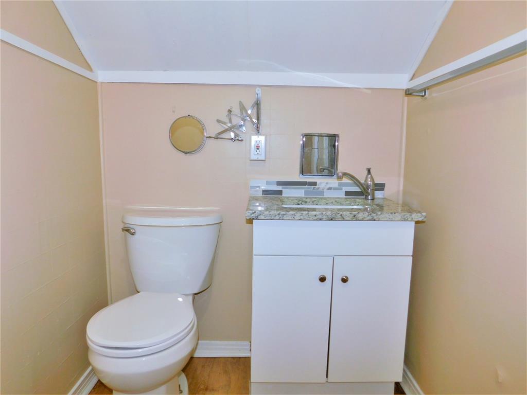 216 Maple Street, Unit 2 Denton, TX 76201 - Photo 14 of 16 a bathroom with a granite countertop toilet sink and mirror