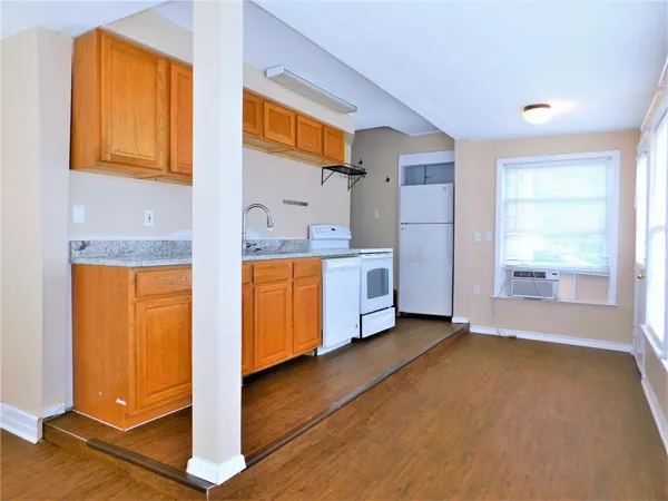 a view of a kitchen with furniture and wooden floor