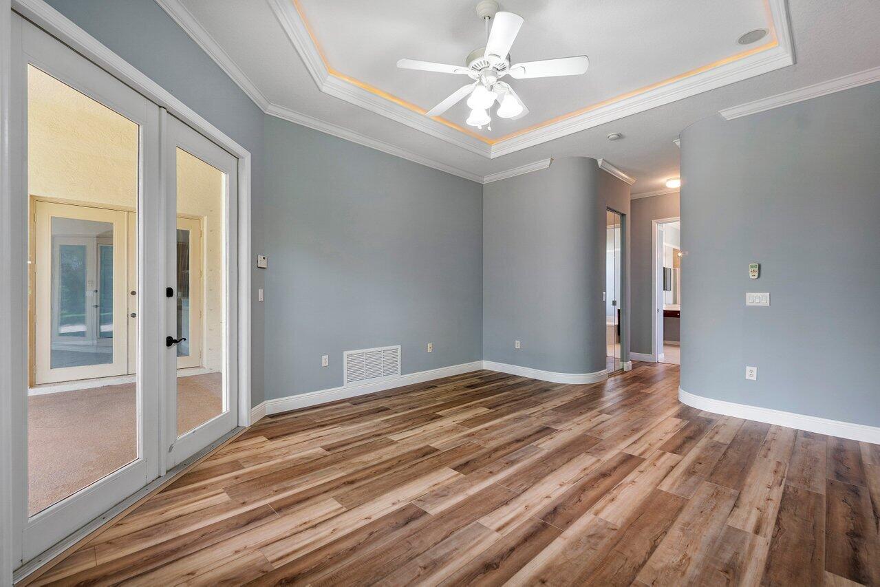 521 Southwest Lake Manatee Way Port St. Lucie, FL 34986 - Photo 15 of 33 a view of empty room with wooden floor and fan