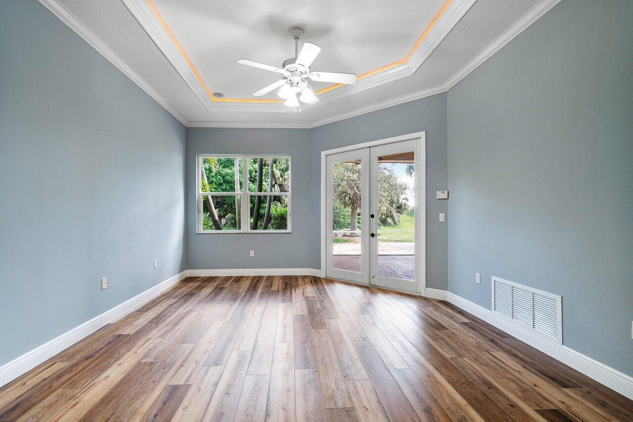 521 Southwest Lake Manatee Way Port St. Lucie, FL 34986 - Photo 16 of 33 a view of an empty room with wooden floor and a window