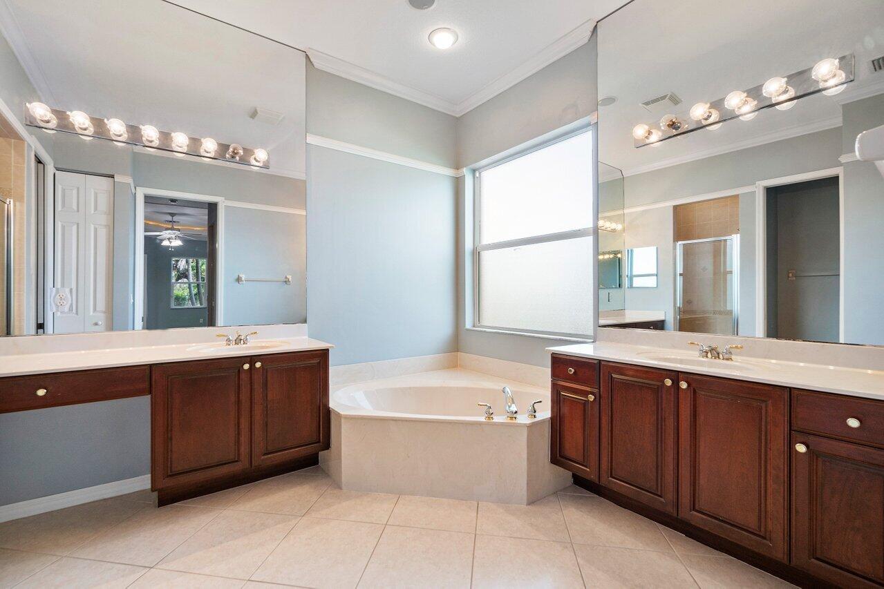 521 Southwest Lake Manatee Way Port St. Lucie, FL 34986 - Photo 18 of 33 a bathroom with a tub a sink double vanity and a mirror