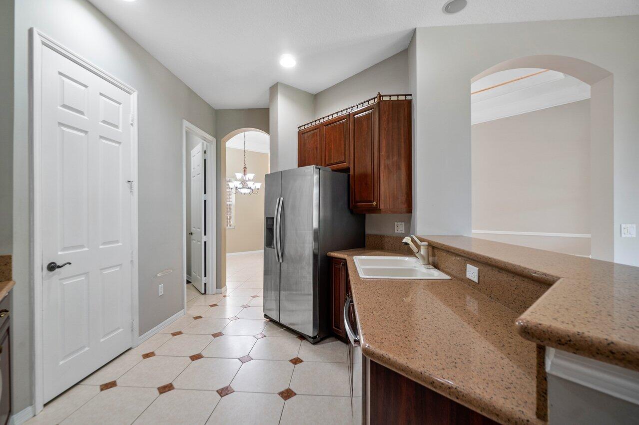 521 Southwest Lake Manatee Way Port St. Lucie, FL 34986 - Photo 7 of 33 a kitchen with refrigerator and cabinet